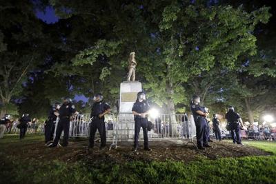 In this Tuesday, Aug. 22, 2017 file photo, police surround the "Silent Sam" Confederate monument during a protest to remove the statue at the University of North Carolina in Chapel Hill, N.C. (AP Photo/Gerry Broome, File)